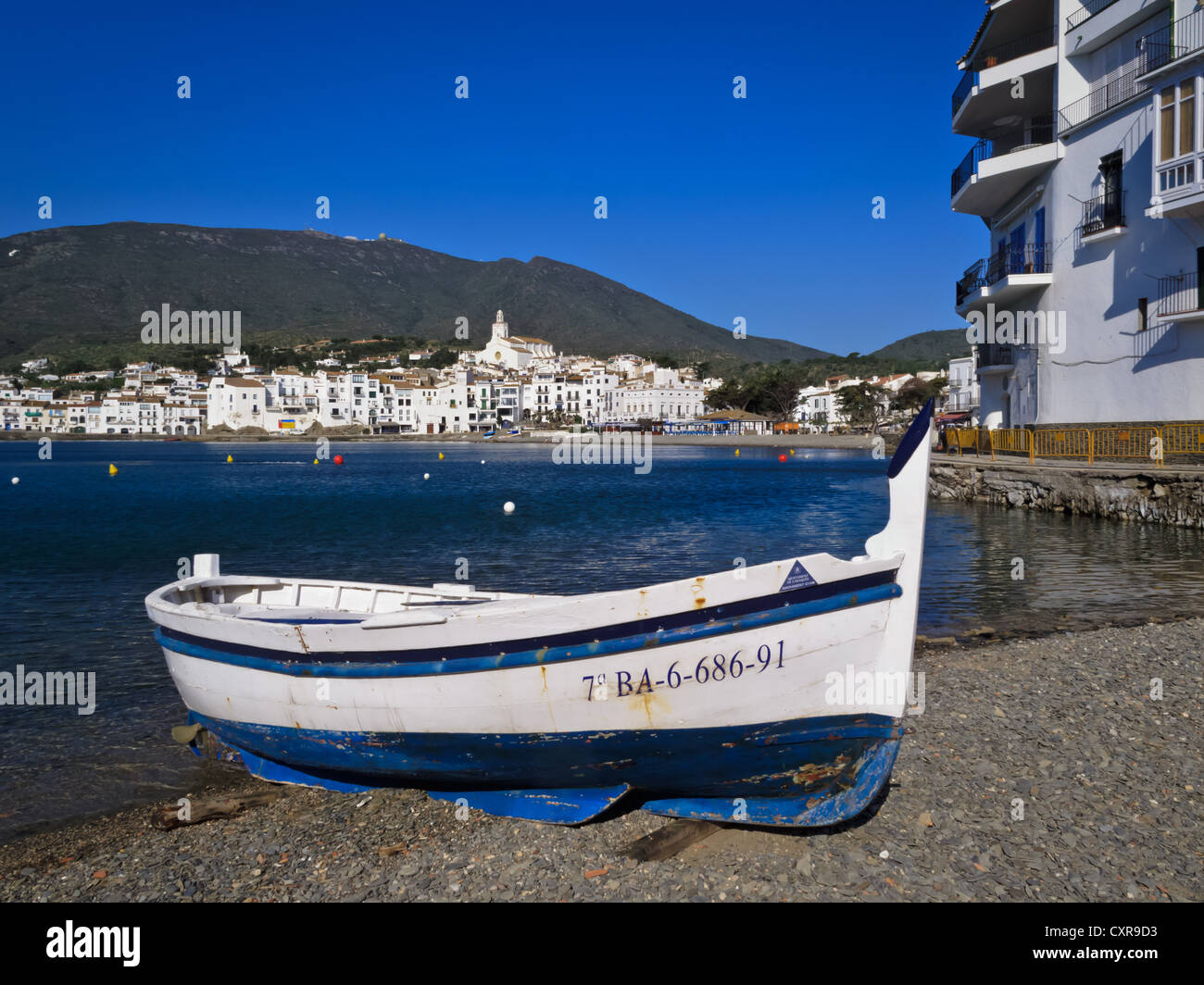 Closeup of blue and white wooden fishing boat resting on pebble beach ...