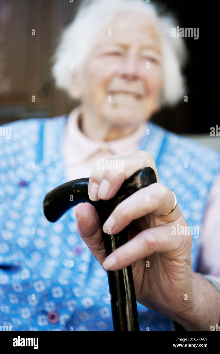 Elderly woman holding a walking cane Stock Photo