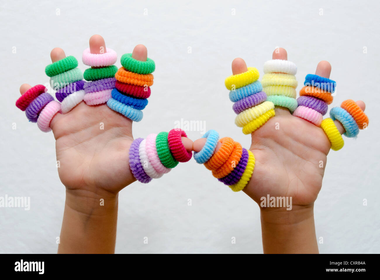 hands of little girl with colorful hair bands Stock Photo