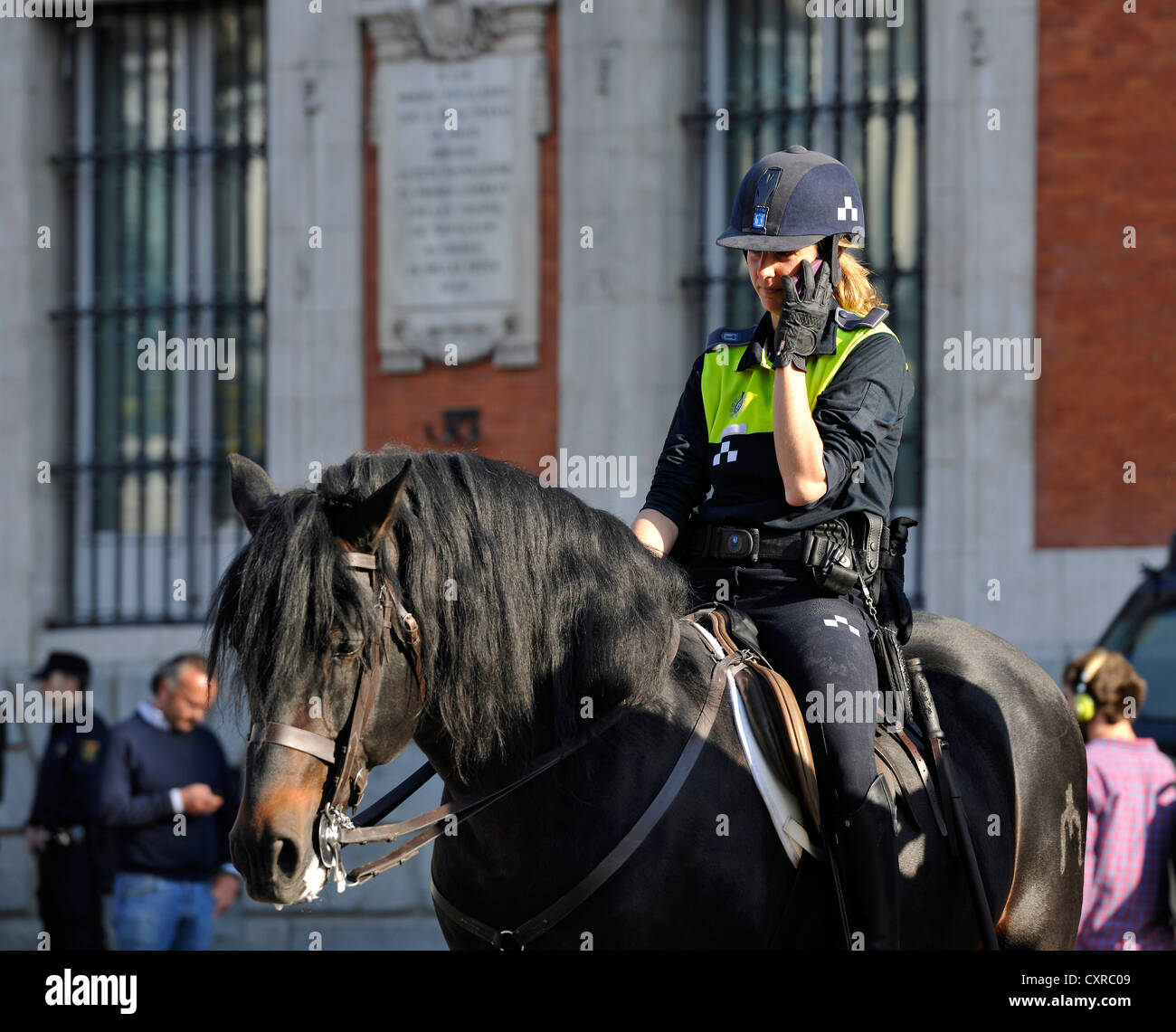 City police on horseback, female police officer speaking on a mobile phone, Plaza Puerta del Sol square, Madrid, Spain, Europe Stock Photo