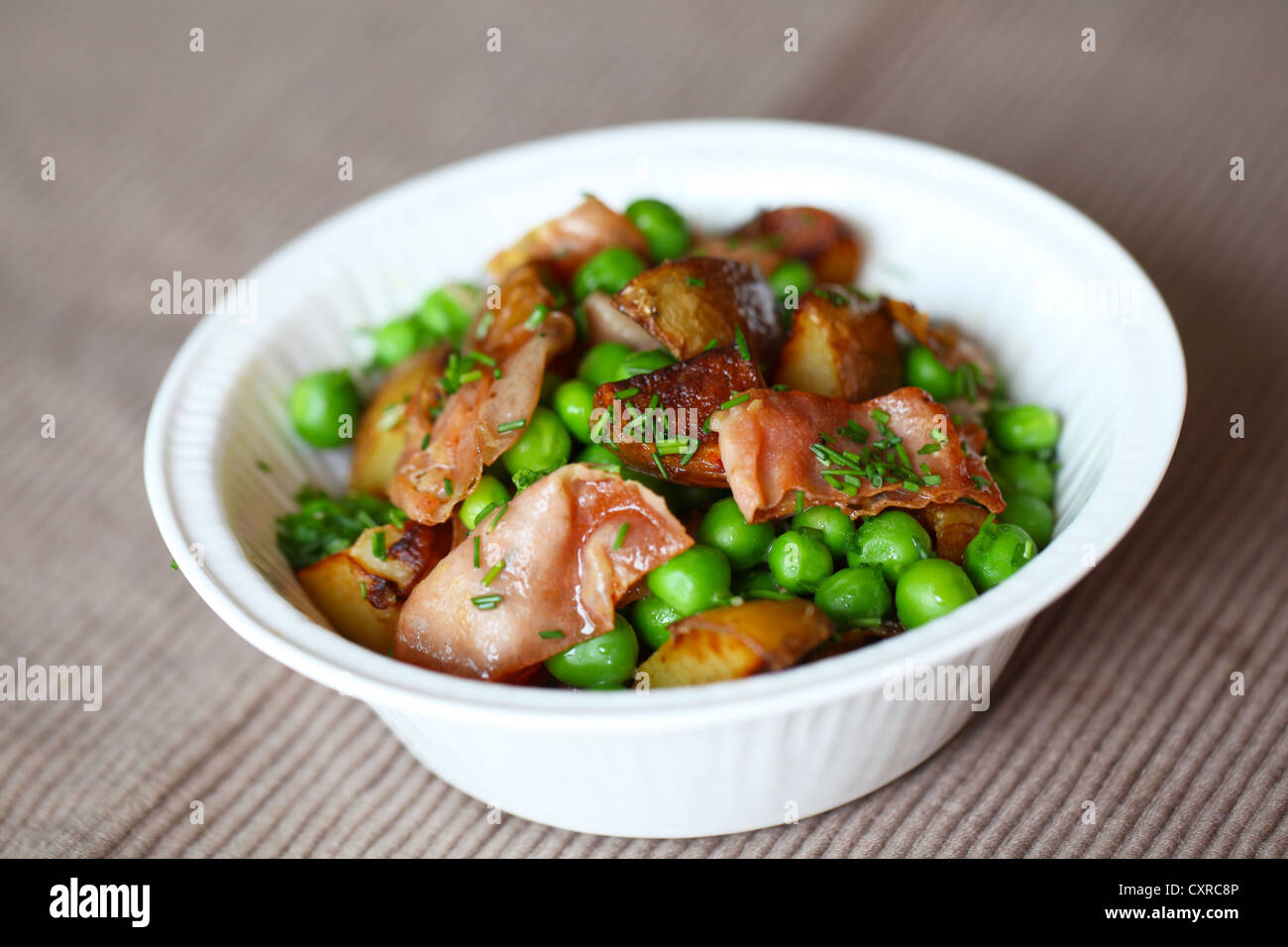 Green pea, baked potato and ham salad with dill. Stock Photo
