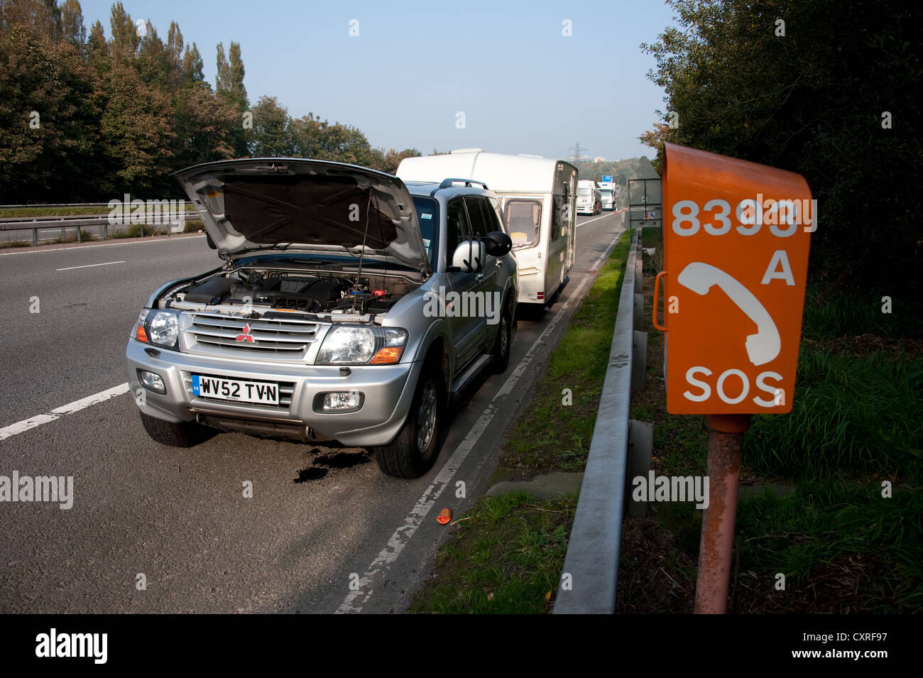 Mitsubishi Shogun Car towing caravan broken down on hard shoulder of motorway UK Stock Photo