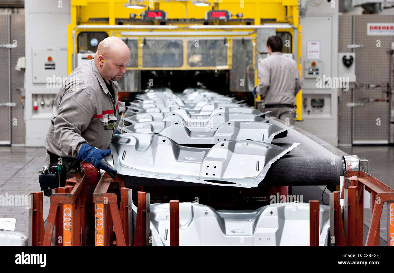 Employees of AUDI AG at work, ergonomically assisted stacking of finished body panels, pressing