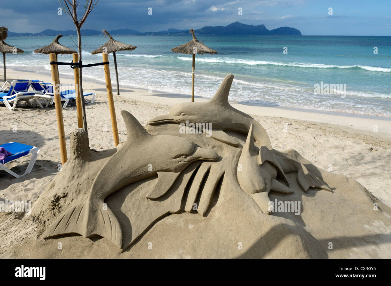 Dolphins as sand sculptures on the beach of C'an Picanfort, Majorca