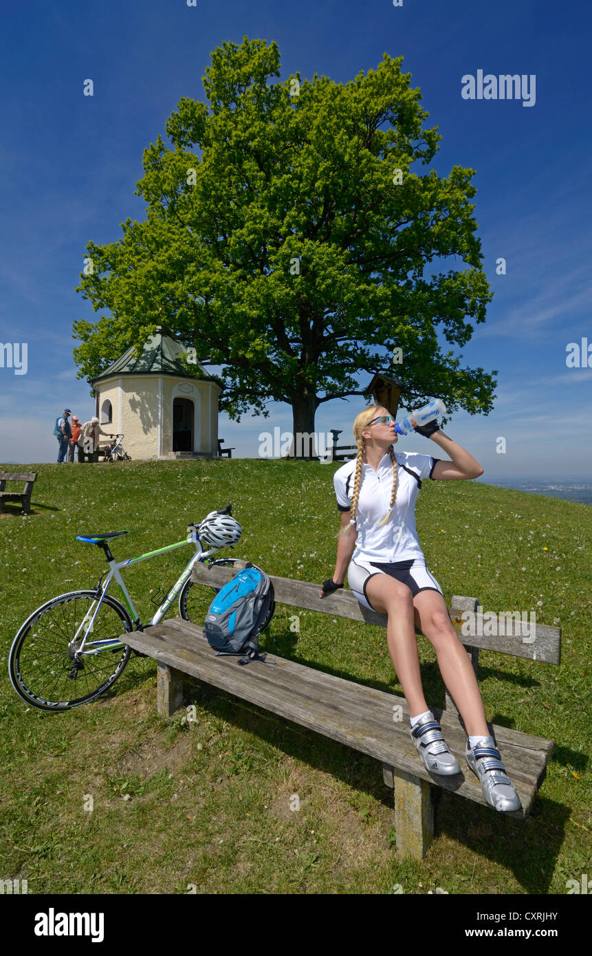 Female cyclist taking a break in front of the Luitpold Oak, Toerwang