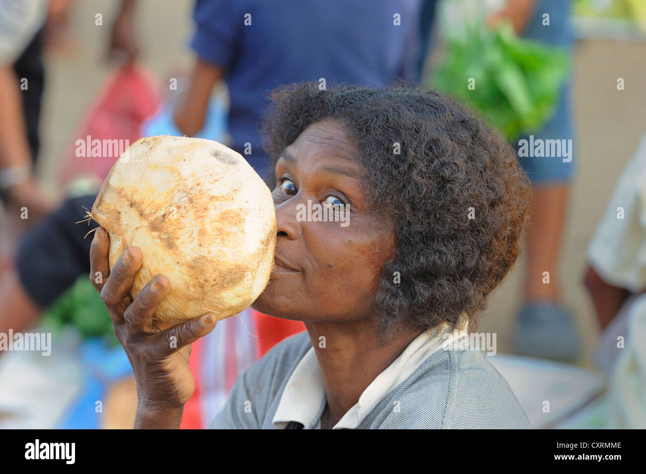 Papuan woman is drinking coconut milk as a substitute for water from