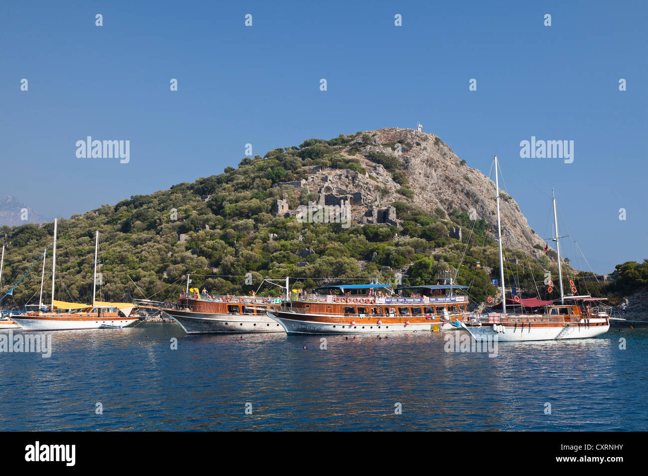 Excursion boats off Gemiler island in the Gulf of Fethiye, Lycian coast, Lycia, Mediterranean Sea, Turkey Stock Photo