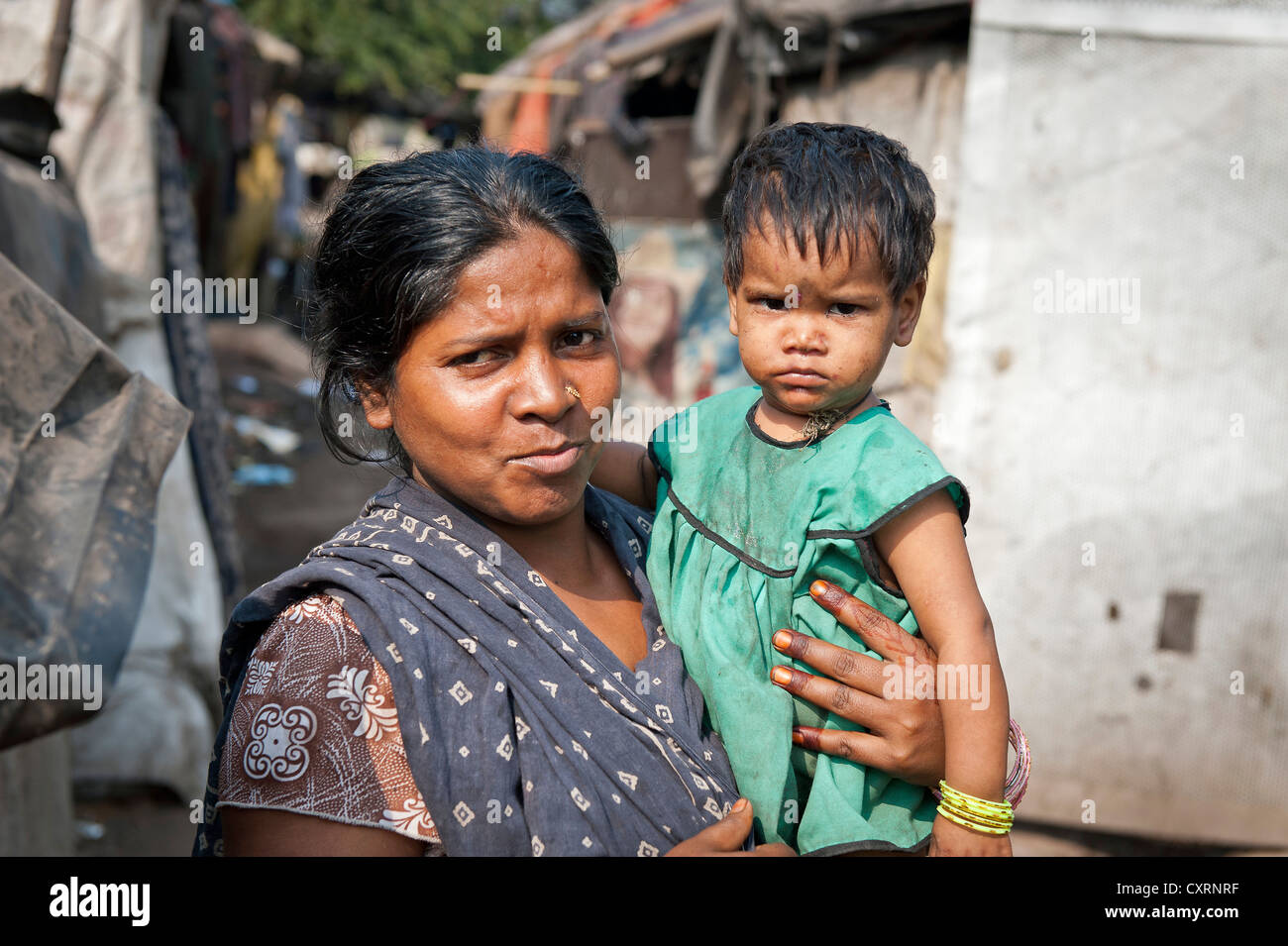 Woman with a toddler in her arms, slum, Shibpur district, Haora or Howrah, Kolkata or Calcutta, West Bengal, East India, India Stock Photo