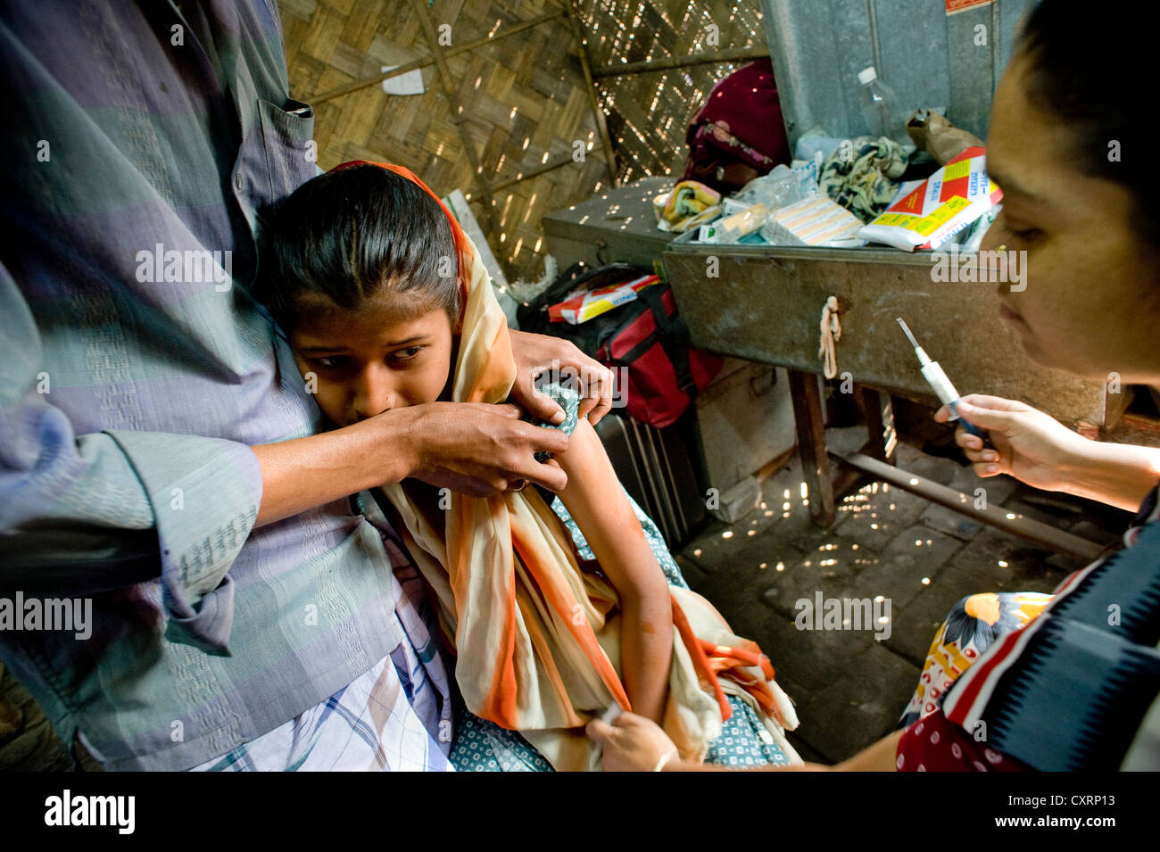 Girl getting a vaccination, clinic set up in a bamboo hut by the aid organisation "Aerzte fuer die Dritte Welt", German for Stock Photo