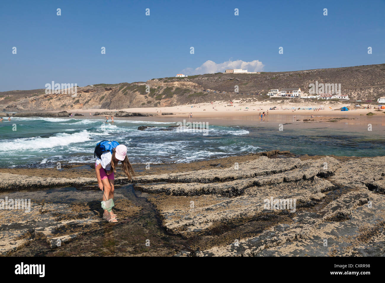 Girl fishing in a tidal pool on the beach of Monte Clerigo, Atlantic Coast, Algarve, Portugal, Europe Stock Photo