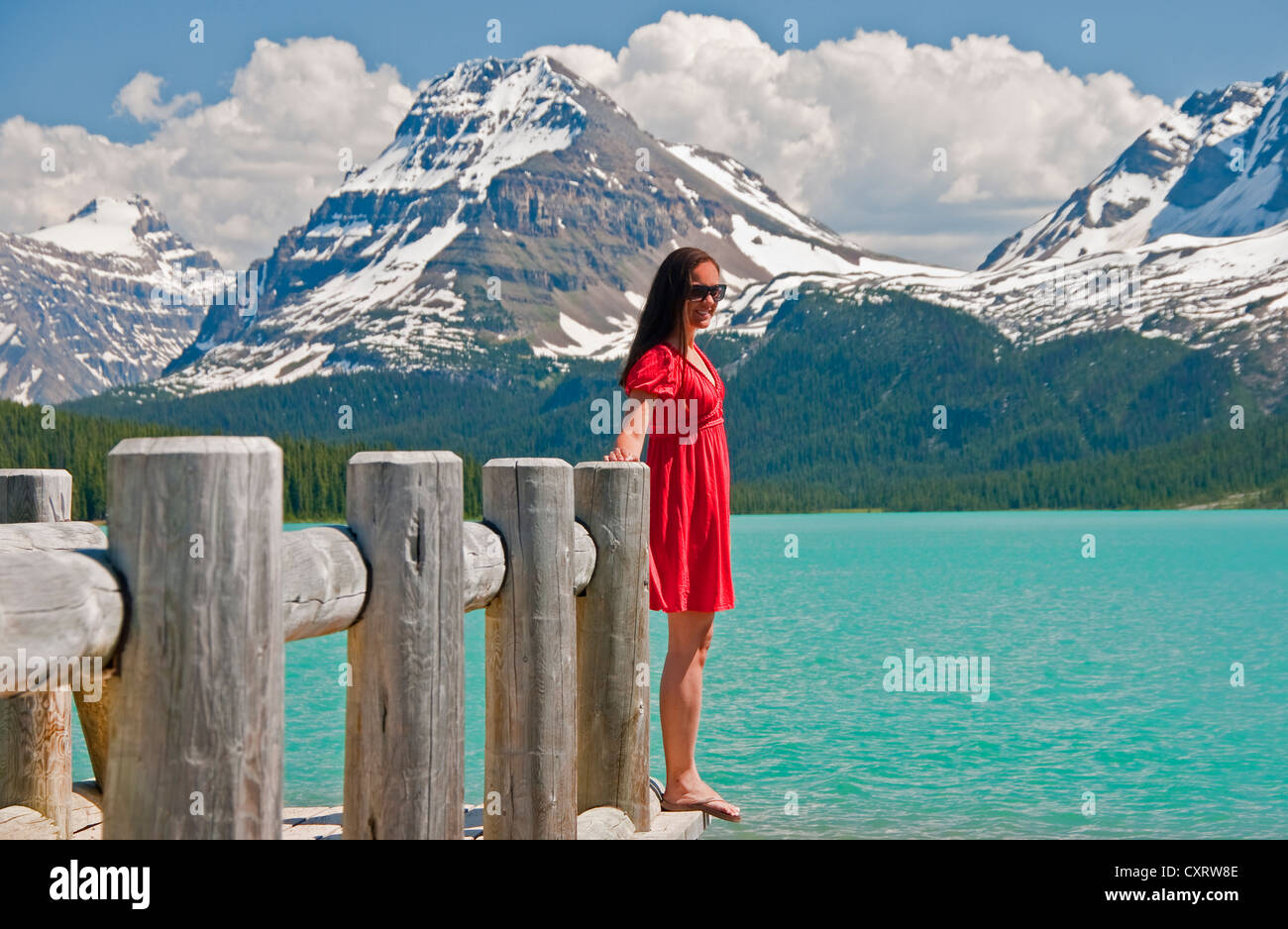 Young woman in red dress at Bow Lake in Banff National Park, Alberta Stock Photo