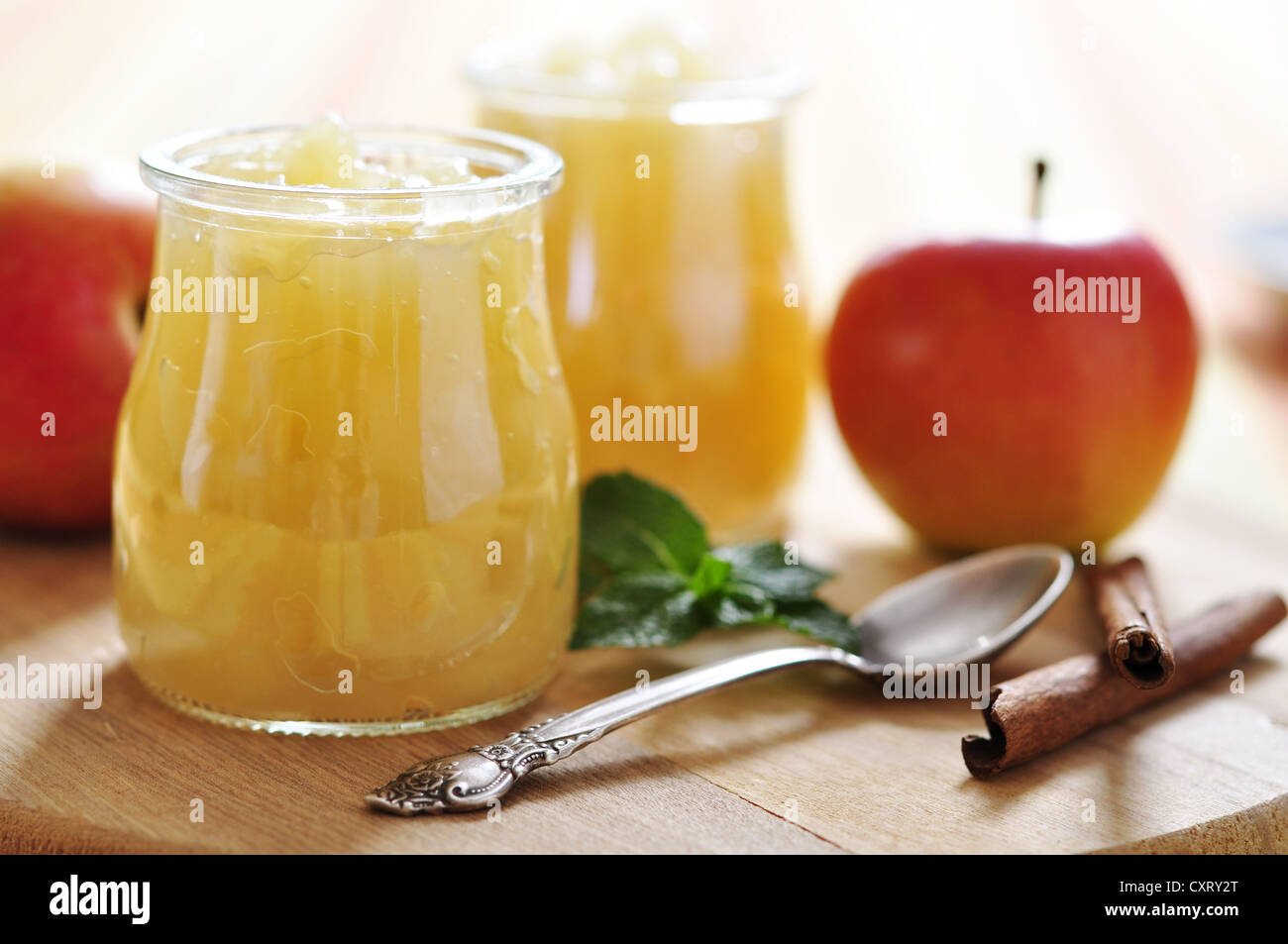 Apple jam with cinnamon and mint on wooden cutting board. Small shallow dof. Stock Photo