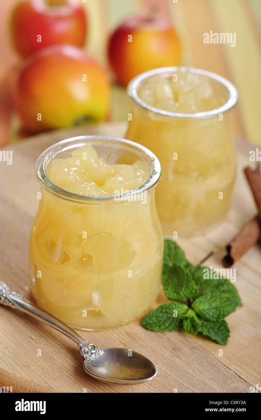 Jar of apple jam with cinnamon and mint on cutting board Stock Photo