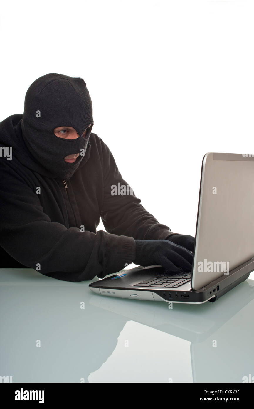 Hacker surfing the internet with a laptop computer, symbolic image for computer hacking, computer or cyber crime, data theft Stock Photo
