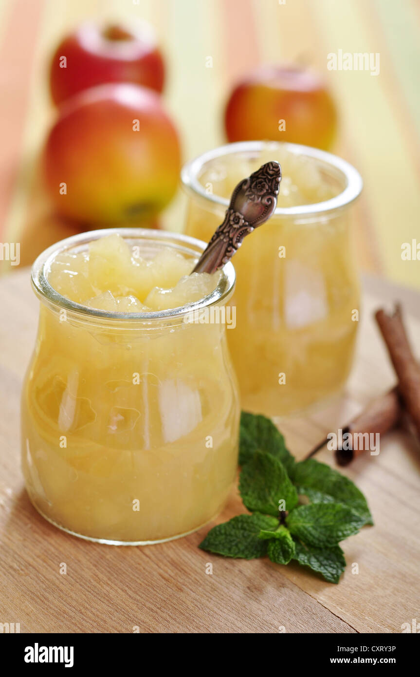 Jar of apple jam with cinnamon and mint on cutting board. Small shallow dof. Stock Photo