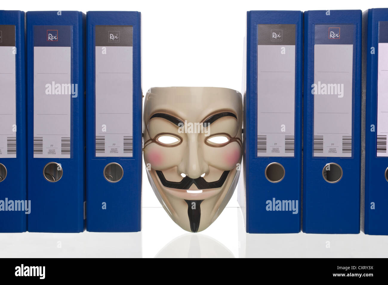 'Anonymous', Guy Fawkes or 'V for Vendetta' mask, wedged between blue unlabelled folders Stock Photo