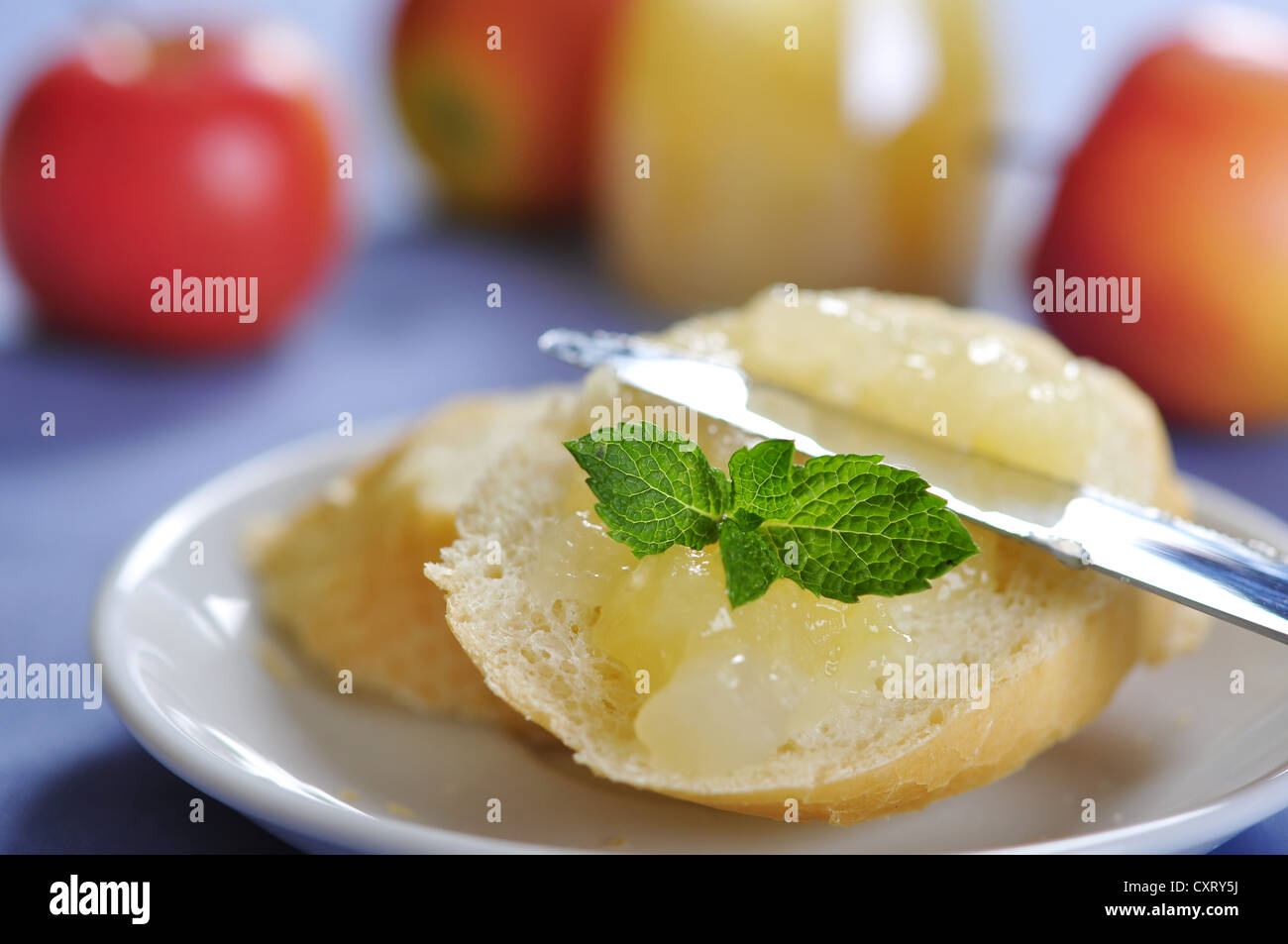 Sliced bun with apple jam on plate. Small shallow dof. Stock Photo