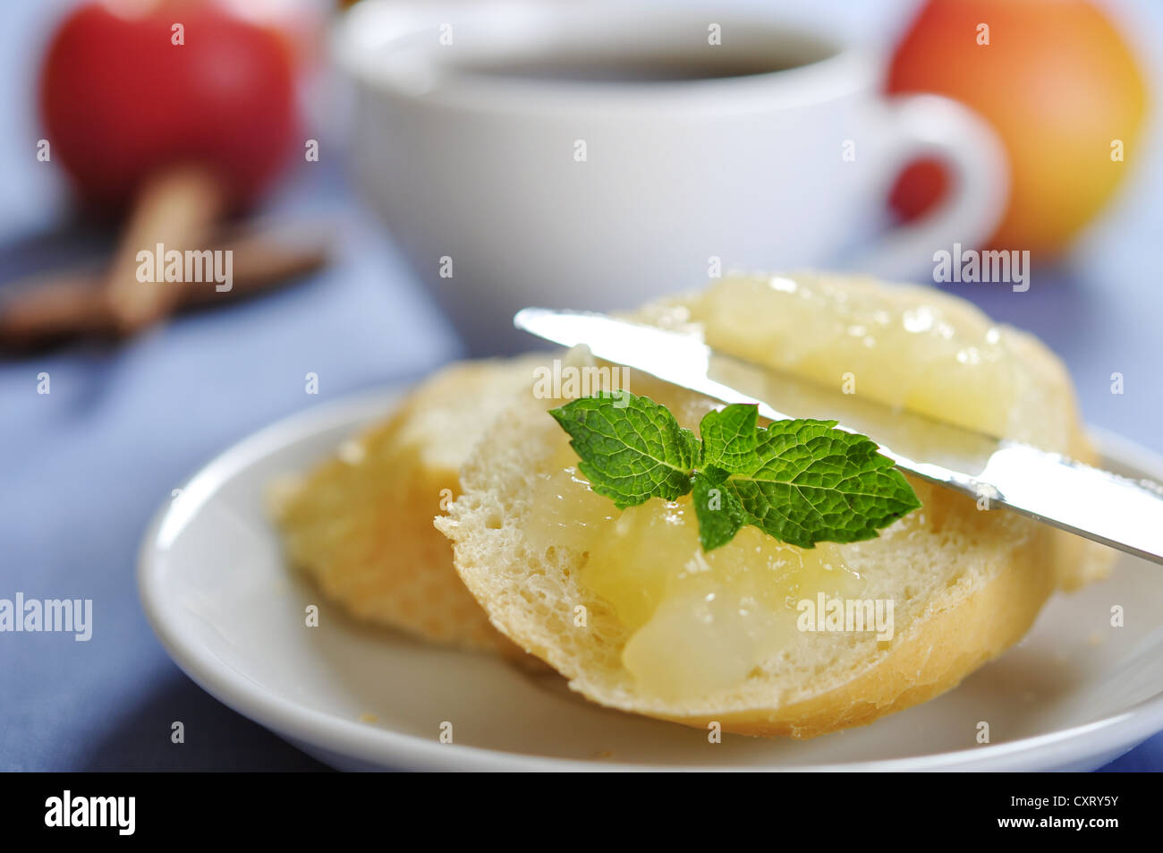 Sliced bun with apple jam on plate. Small shallow dof. Stock Photo