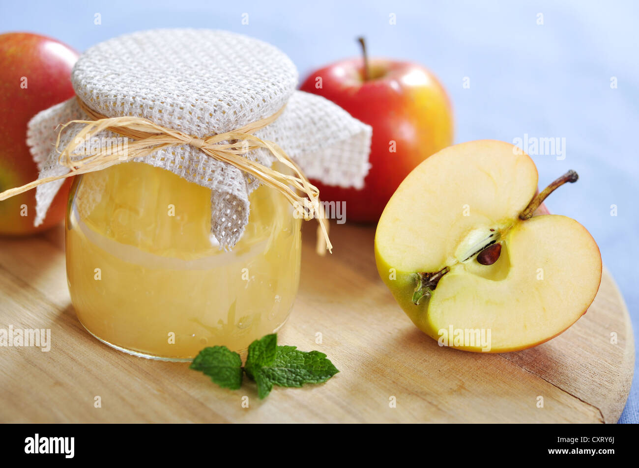 Jar with apple jam and fresh apples on wooden cutting board Stock Photo