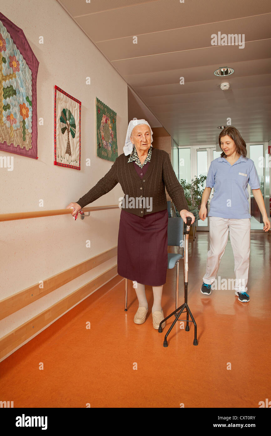 Old woman with a physiotherapist 4 point cane stock photo alamy