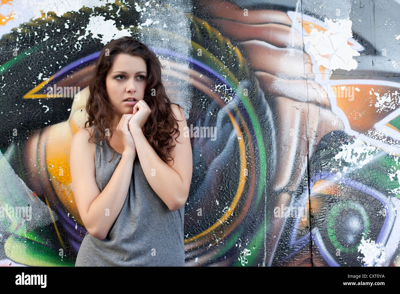 Young Woman In A Grey Dress Posing In Front Of A Graffiti Wall Stock Photo Alamy