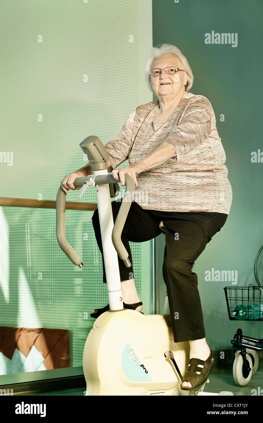 Obese woman on an ergometer, rehab, nursing home Stock Photo