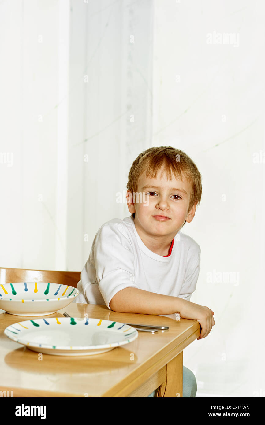 Boy sitting at the dinner table Stock Photo Alamy
