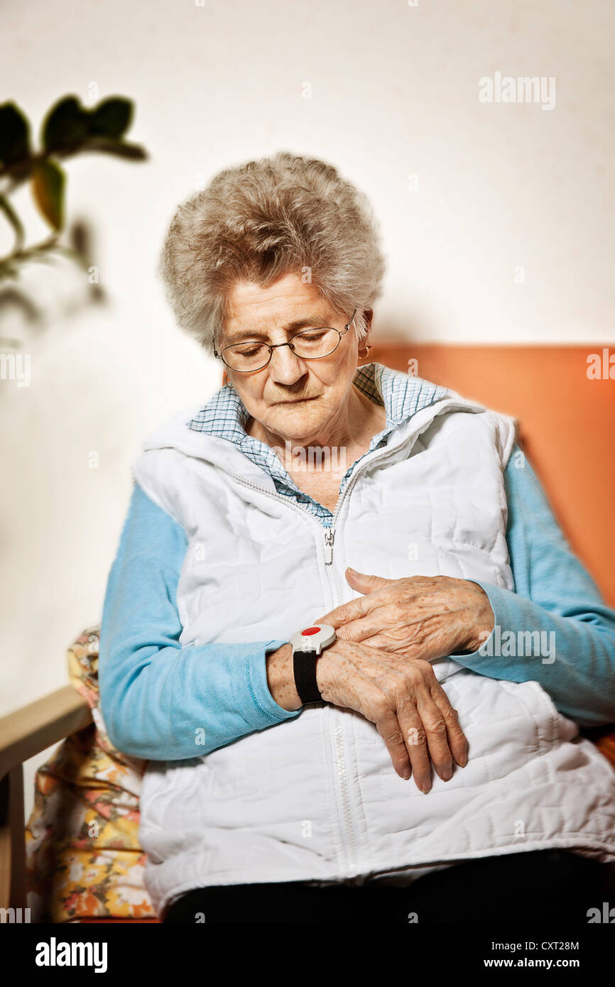 Elderly woman wearing an emergency transmitter on her wrist Stock Photo