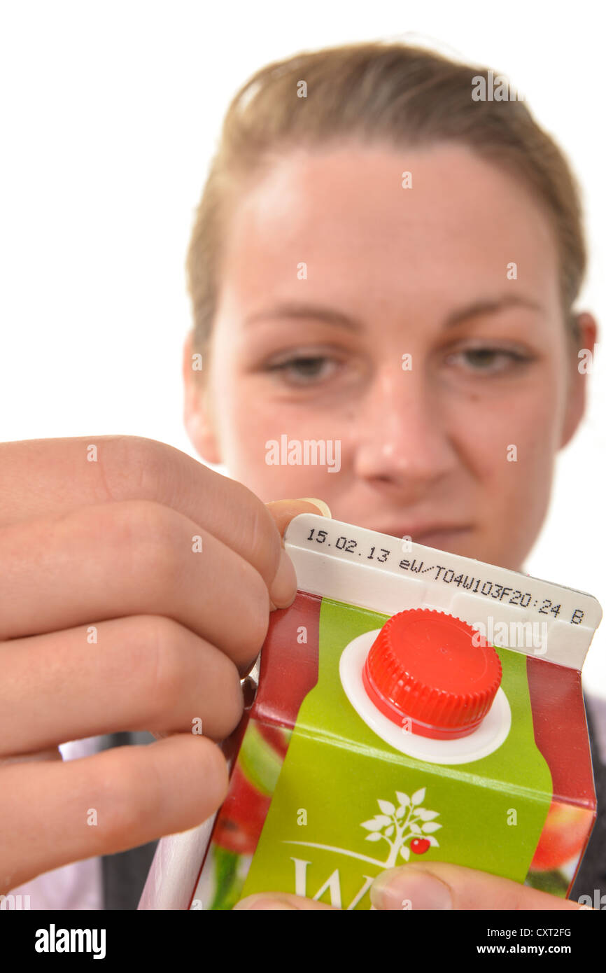 Woman checking the best before or use-by date on a drinks carton Stock Photo