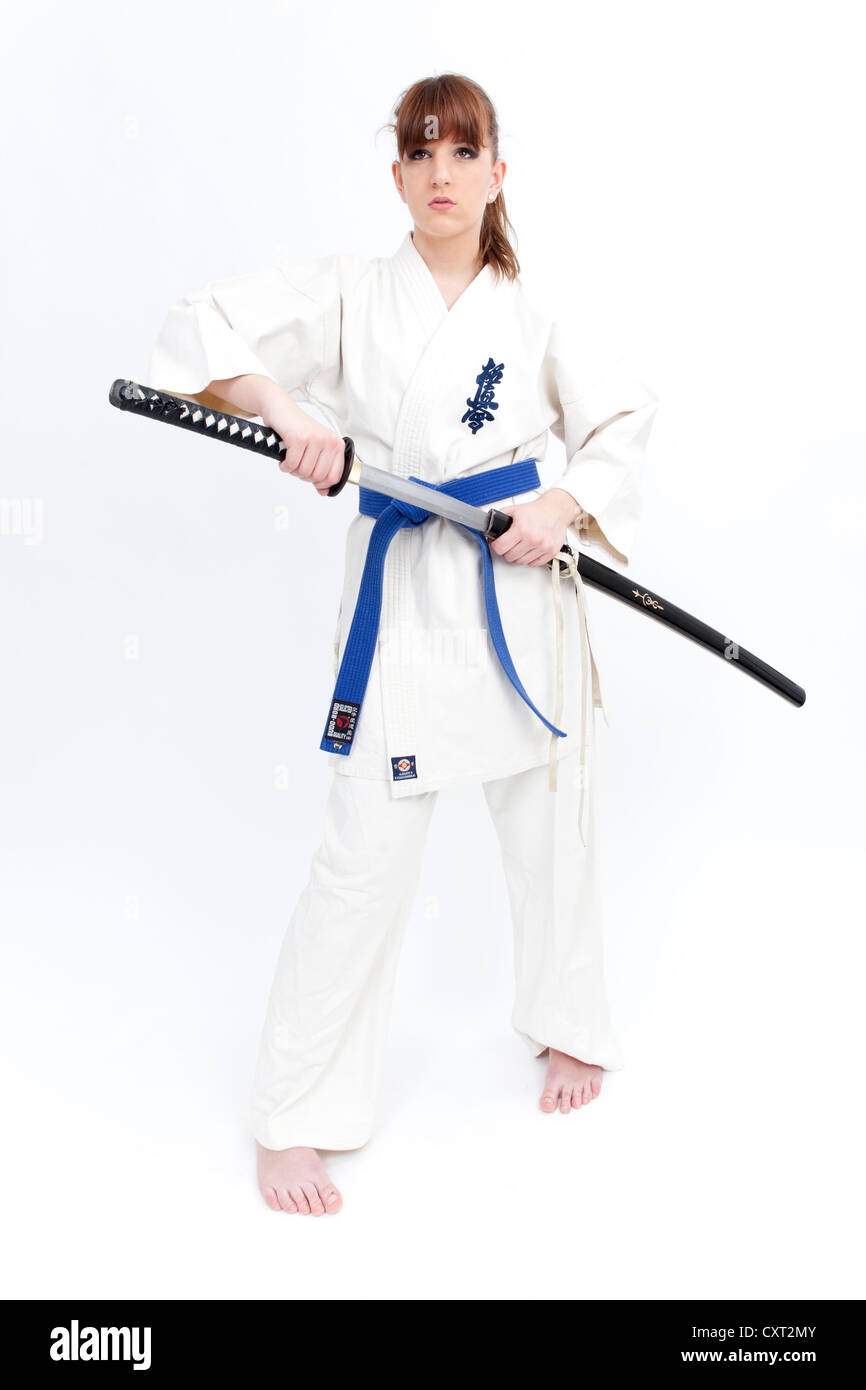 Young woman in a karate suit drawing a sword, saber Stock Photo Alamy