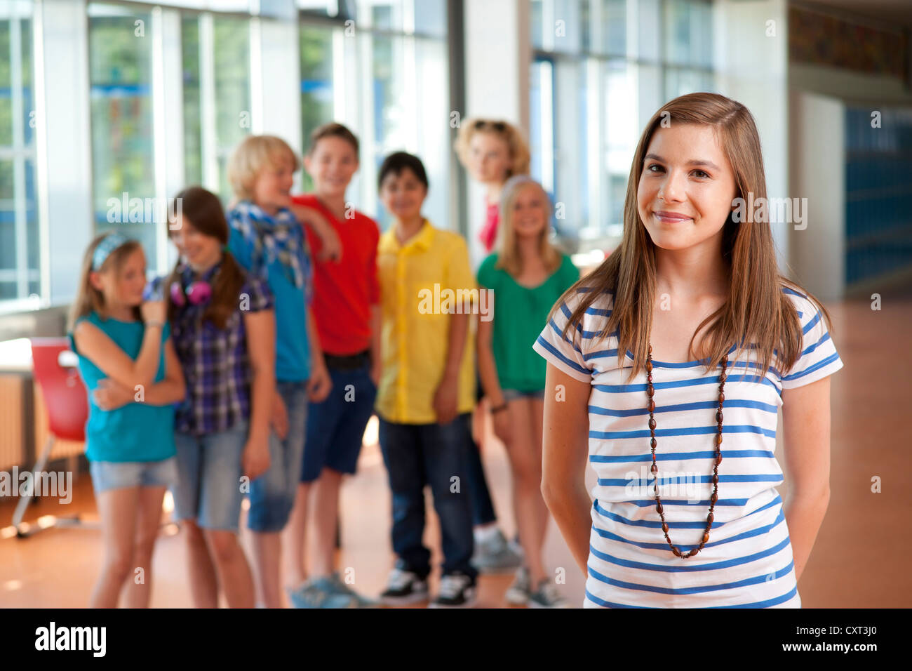 Girl standing in front of a group of schoolchildren Stock Photo - Alamy