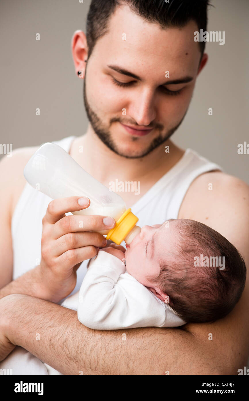 Father lovingly holding his newborn baby in his arms Stock Photo