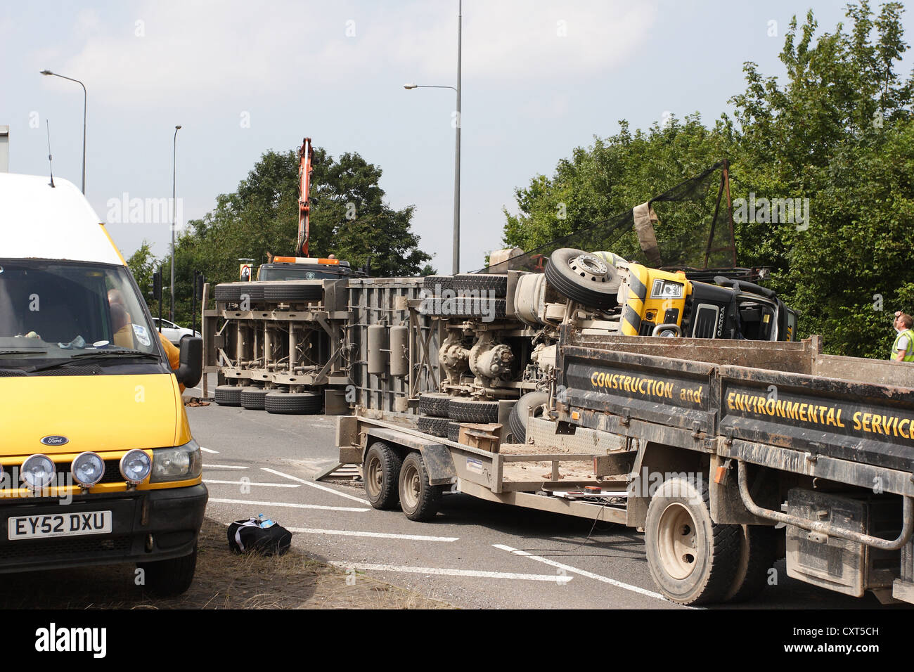 Truck on its side surrounded by vehicles Stock Photo