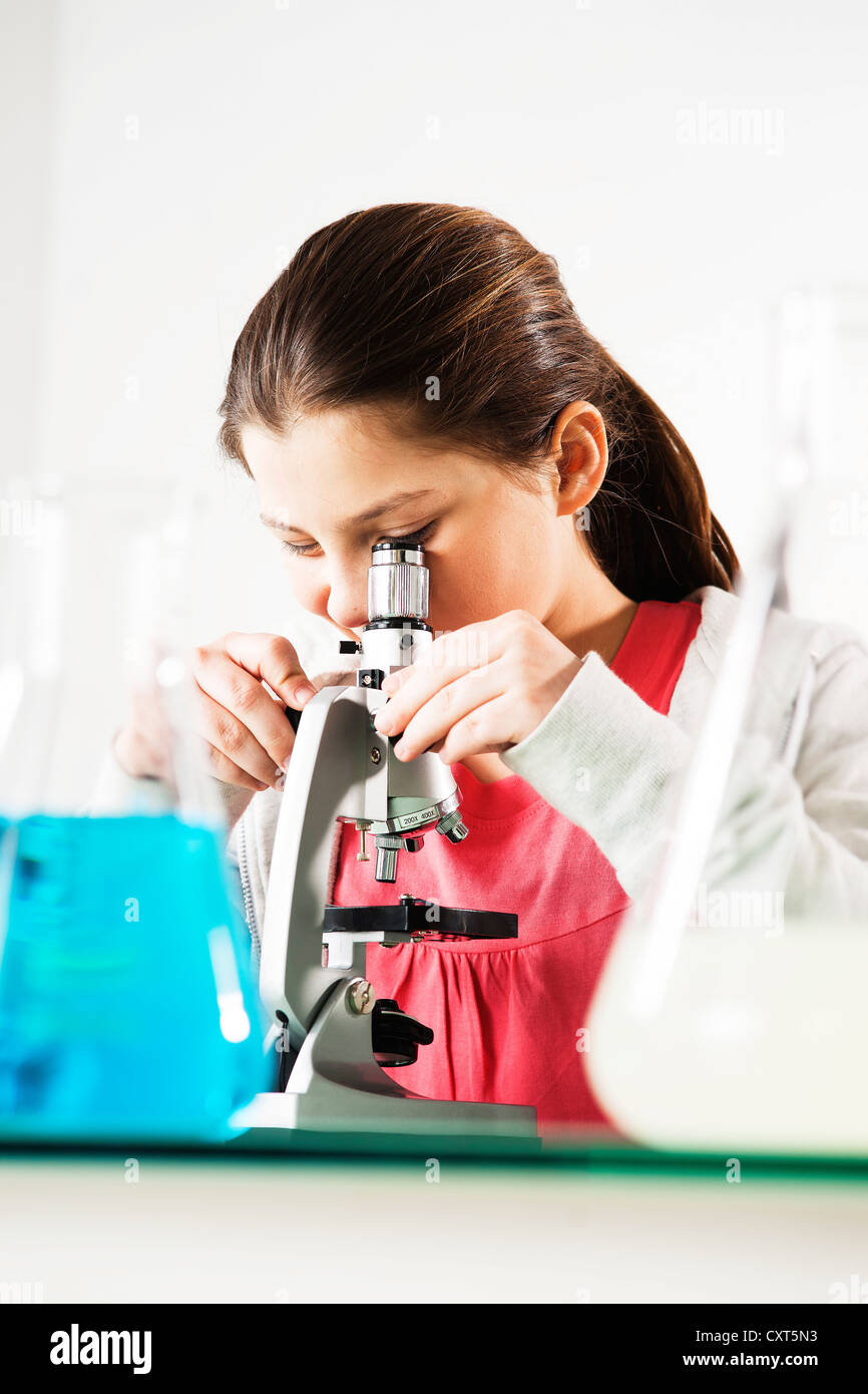 Girl looking into a microscope Stock Photo Alamy