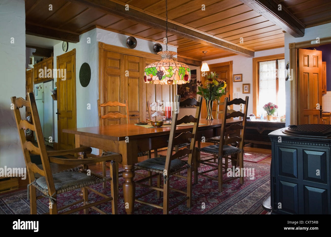 Chairs, table and furnishings in the dining room of a reconstructed old Canadiana cottage-style residential log home, 1978, Stock Photo