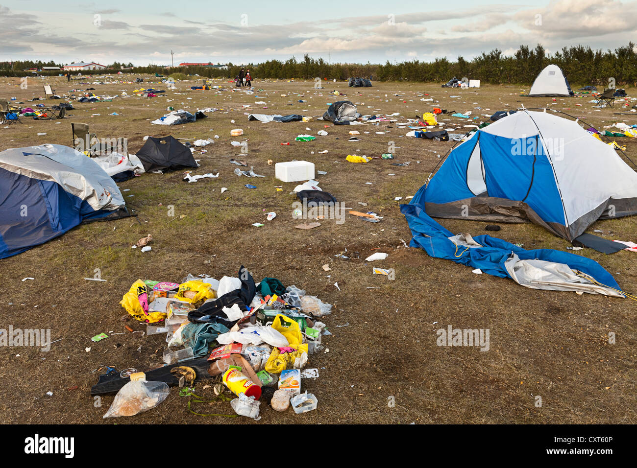 Meadow full of garbage, waste, destroyed tents and broken camping