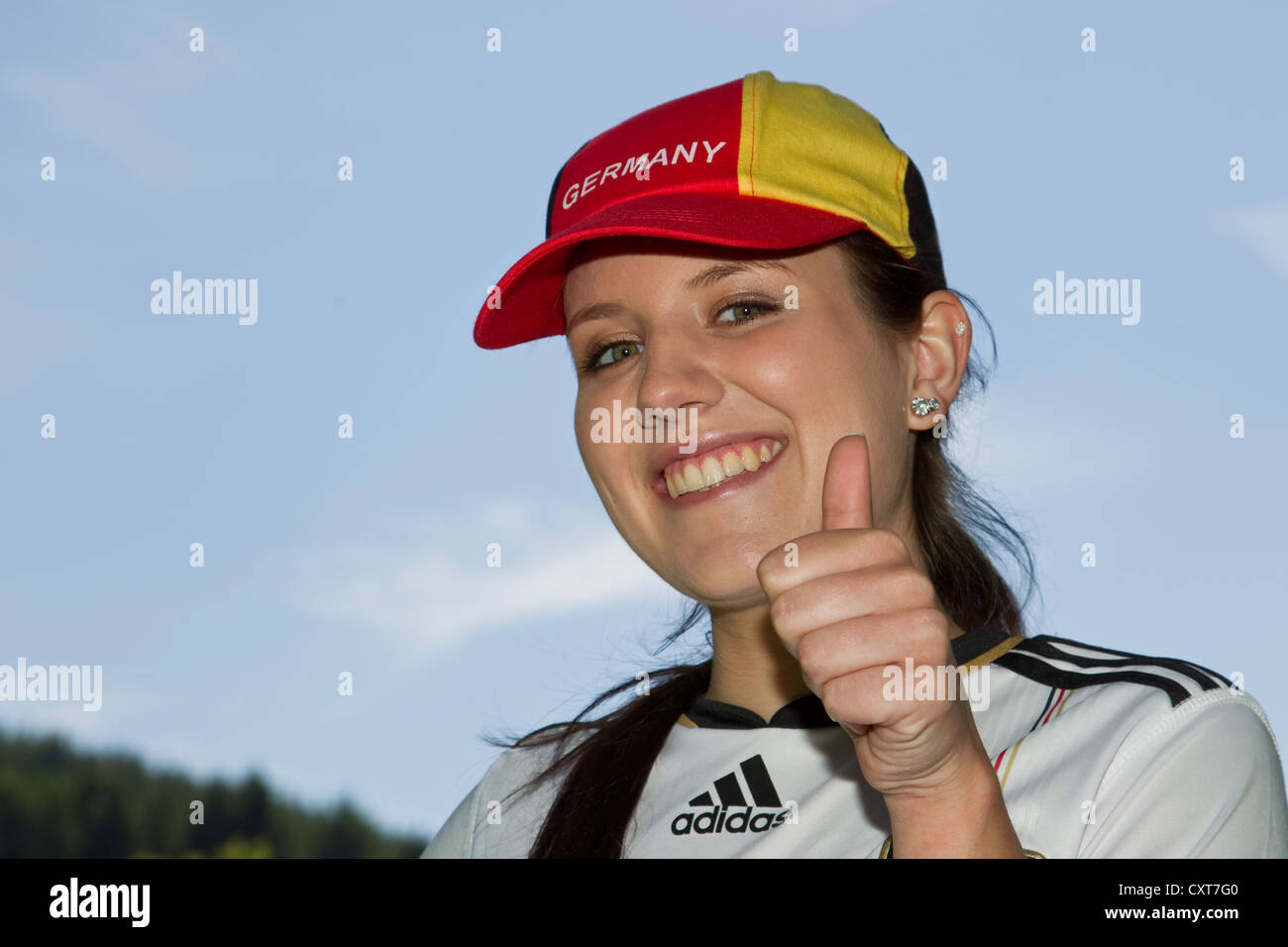 Young woman, football fan wearing a Germany cap and jersey, portrait