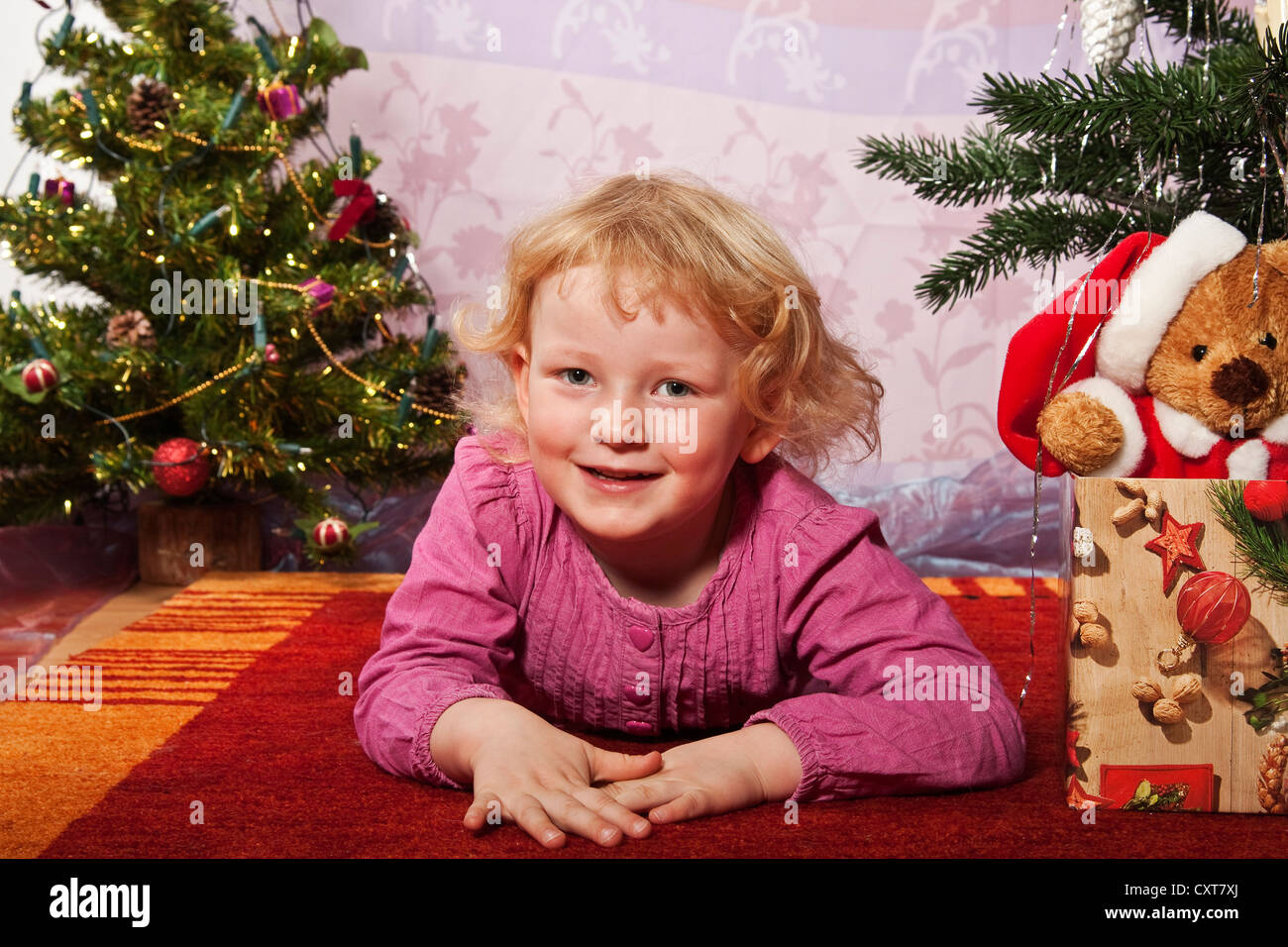 Happy girl, 4, lying on the floor at Christmas Stock Photo - Alamy