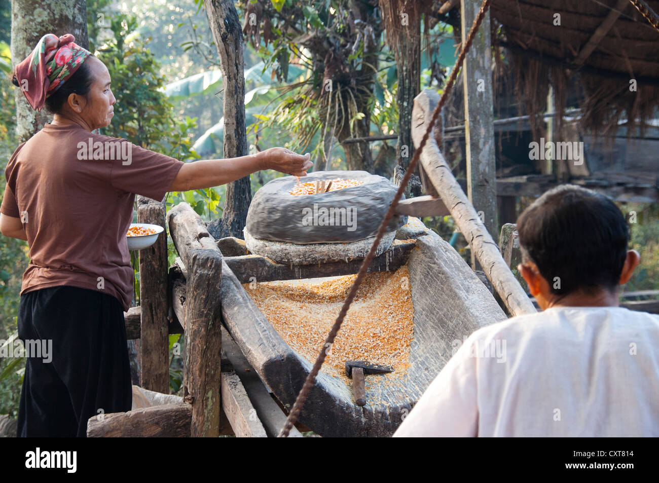 A man and a woman working on a corn mill, village, hill tribe people of