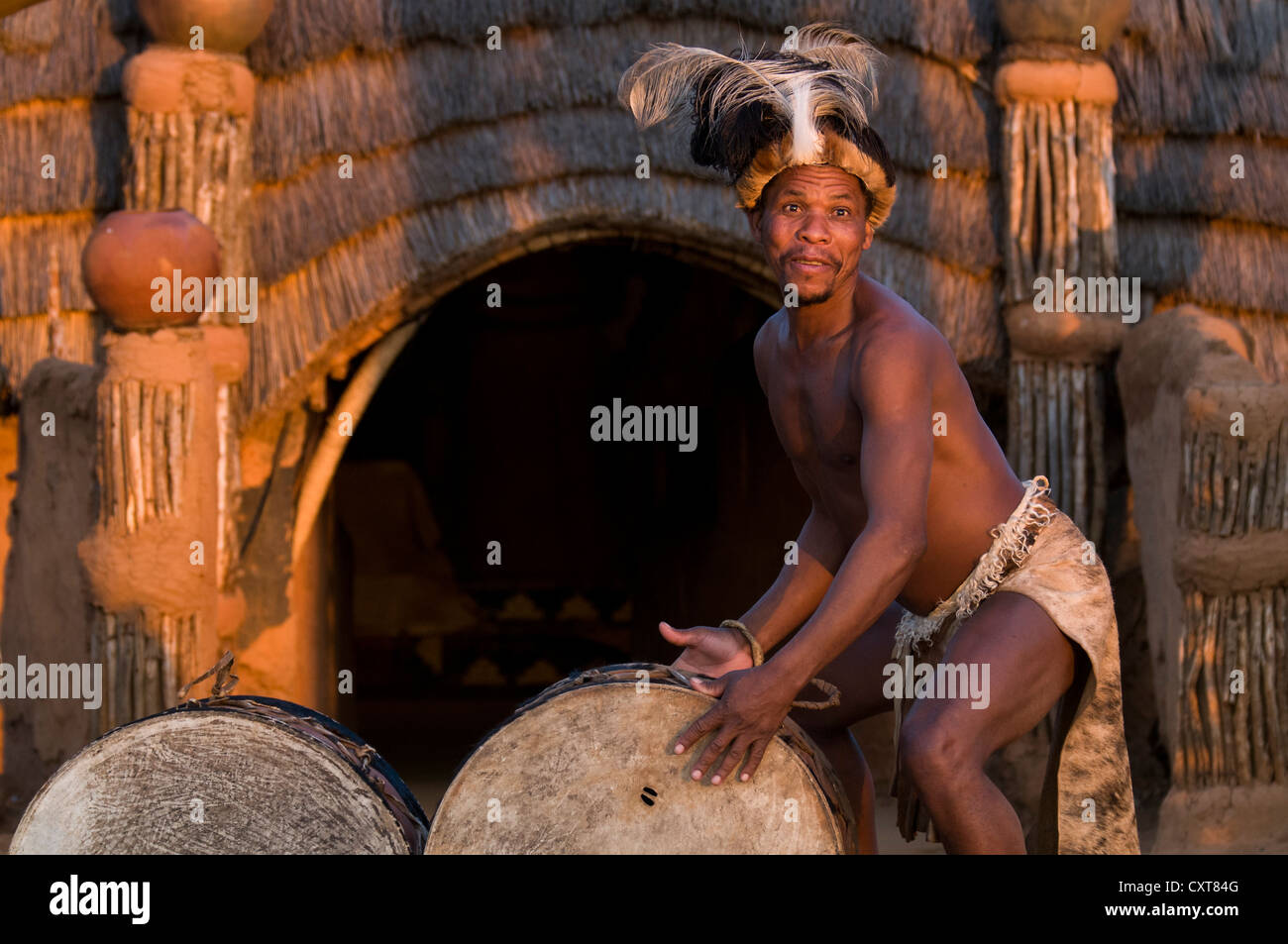Zulu man in traditional costume playing the drums, film set of Shakazulu, Shakaland, KwaZulu-Natal, South Africa, Africa Stock Photo