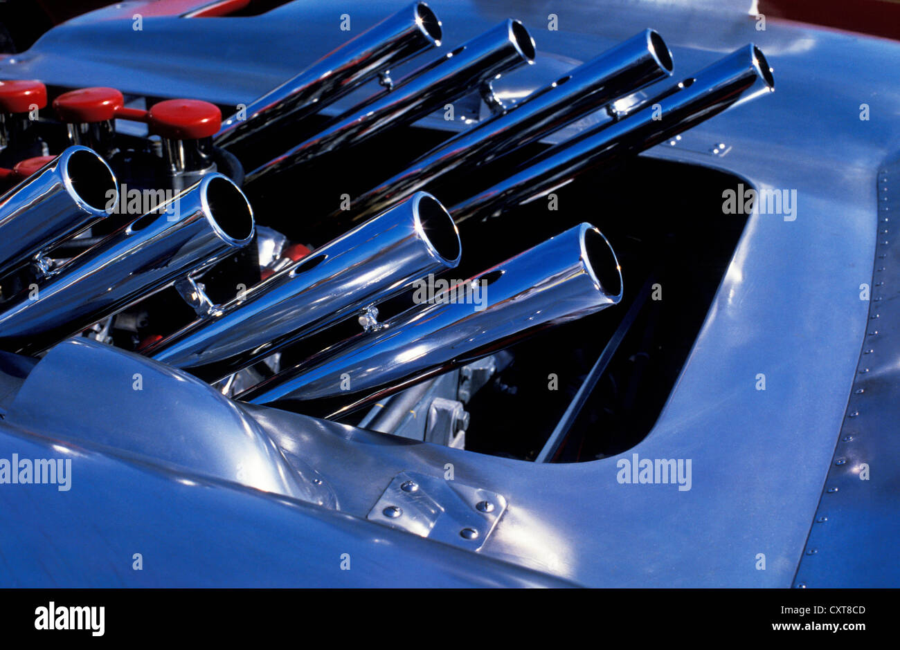 Detail of engine bay in vintage race car showing exhaust pipes and