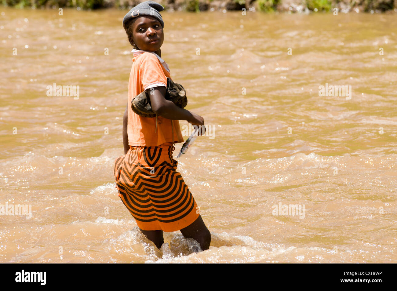 Young Basotho woman wading through a river, Drakensberg, Kingdom of Lesotho, southern Africa Stock Photo