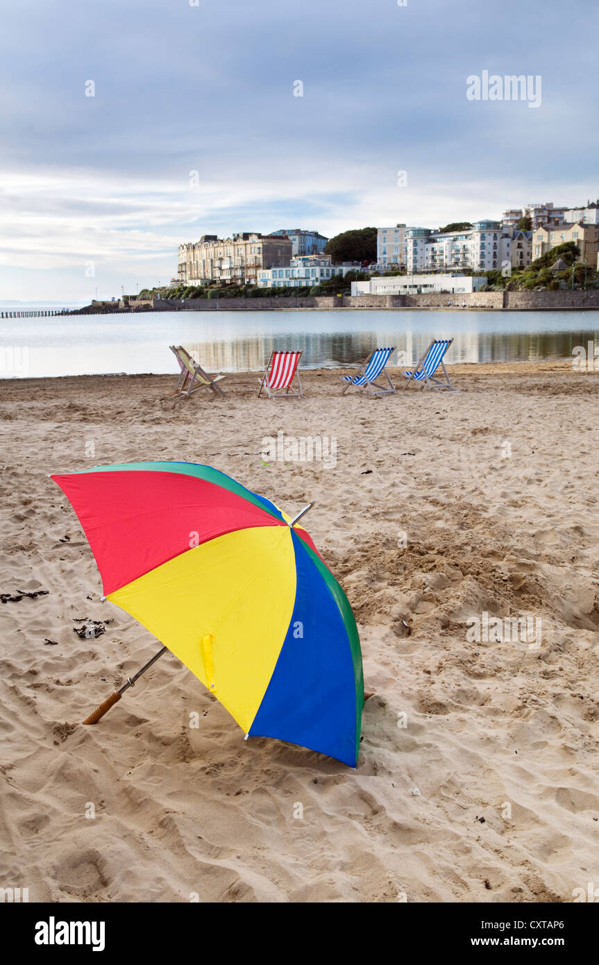Colourful umbrella and deck chairs at Weston Super Mare beach and sea front, England, UK Stock Photo