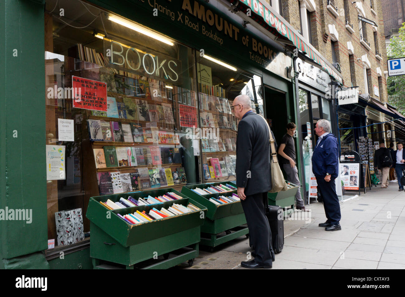 People browsing in the windows of 'Any Amount of Books' in the Charing Cross Road in Central London. Stock Photo