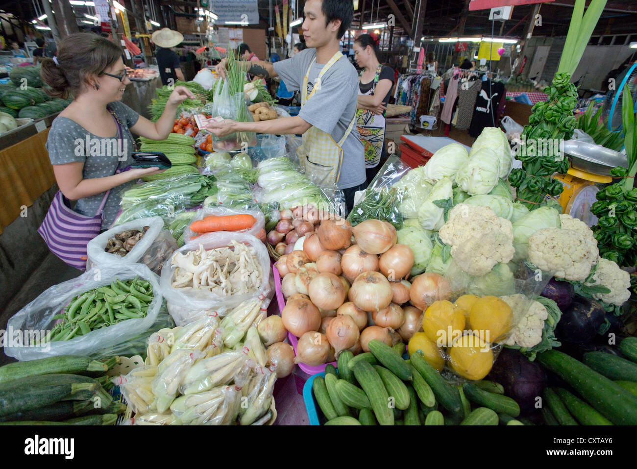 A tourist buys vegetables at a market stall in Chiang Mai, Northern ...