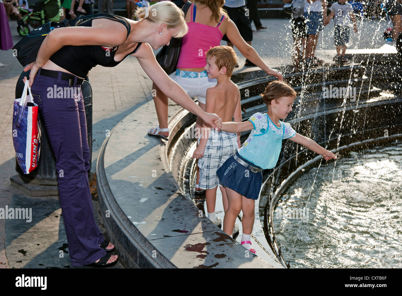 Girl playing in water fountain hi-res stock photography and images - Alamy