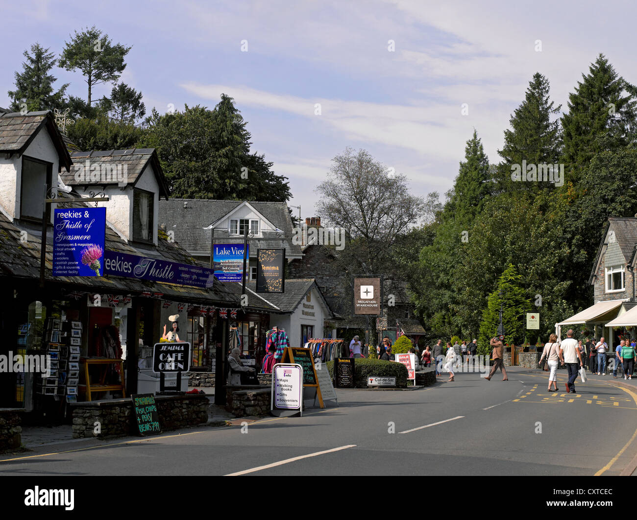People tourists visitors and shops stores in Grasmere village Cumbria England UK United Kingdom GB Great Britain Stock Photo