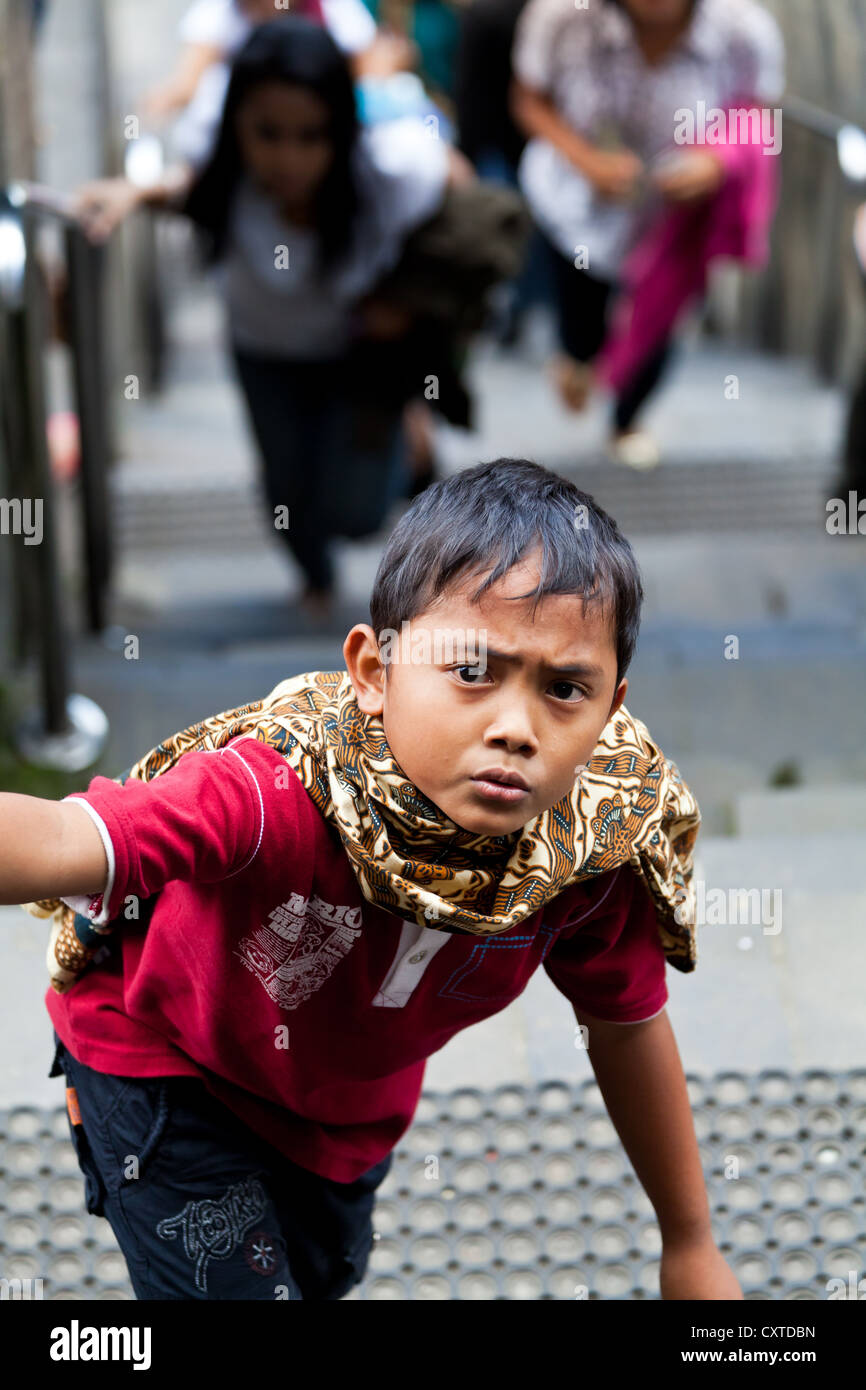 Young Boy climbing up the Buddhist Temple of Borobudur in Indonesia Stock Photo
