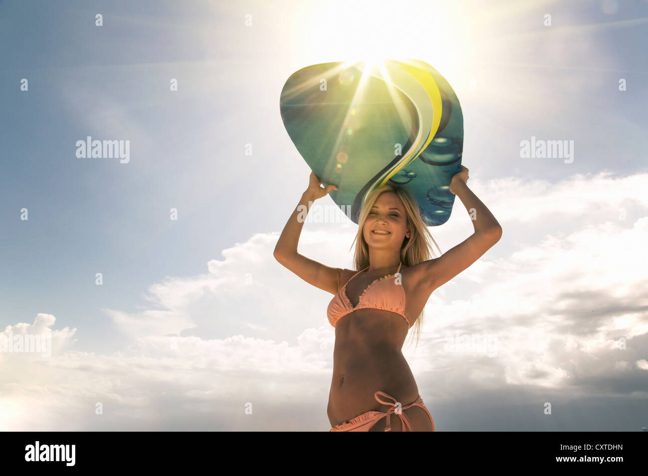 Woman carrying boogie board outdoors Stock Photo