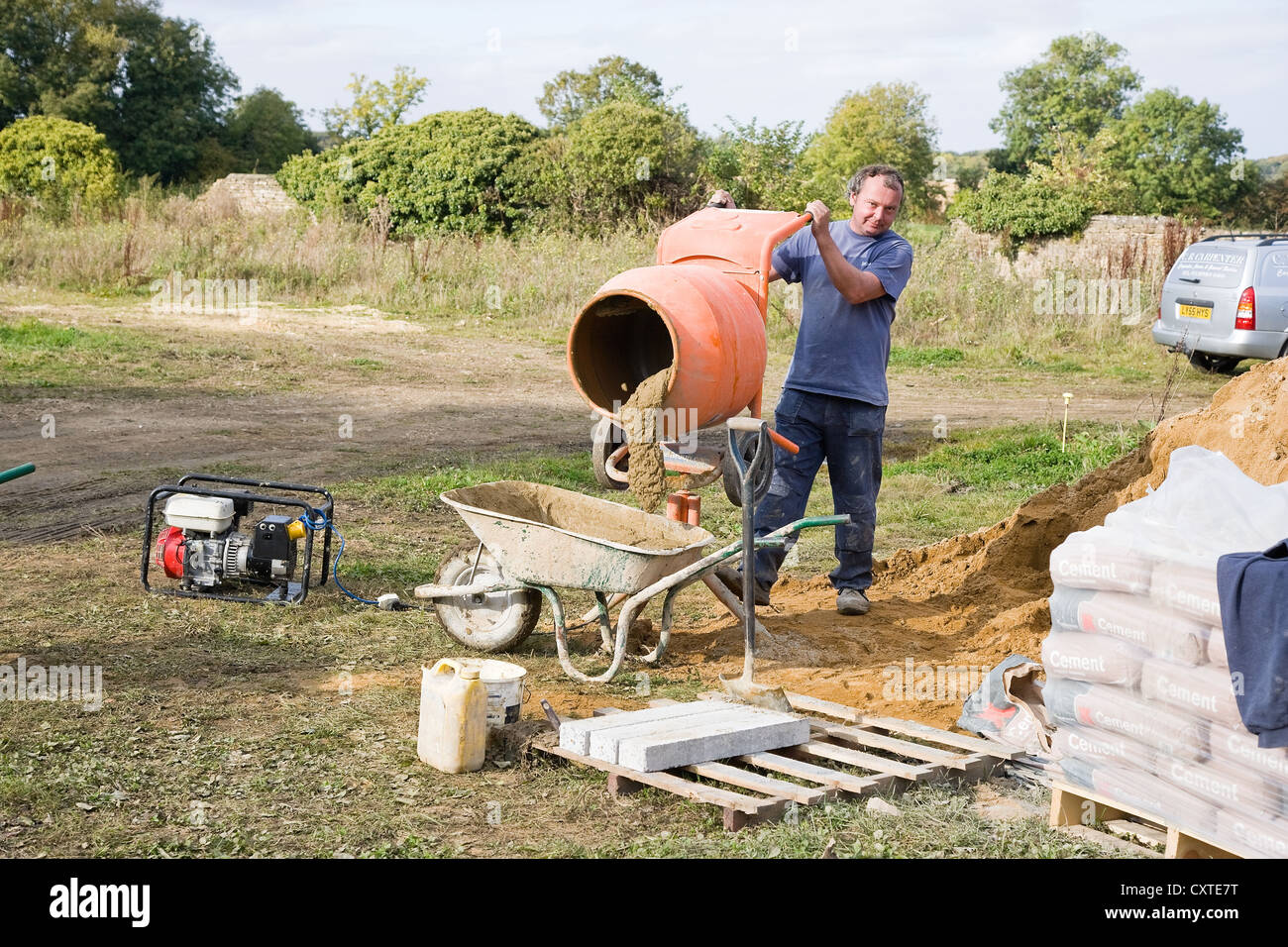 Workman on building site using Cement Mixer Stock Photo Alamy